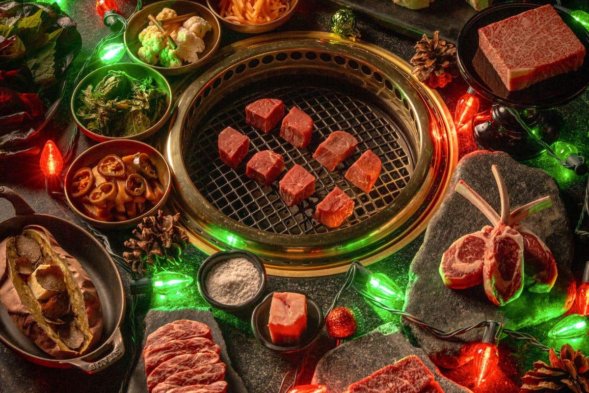 Steak on a hibachi grill surrounded by green and red lights and side dishes. 