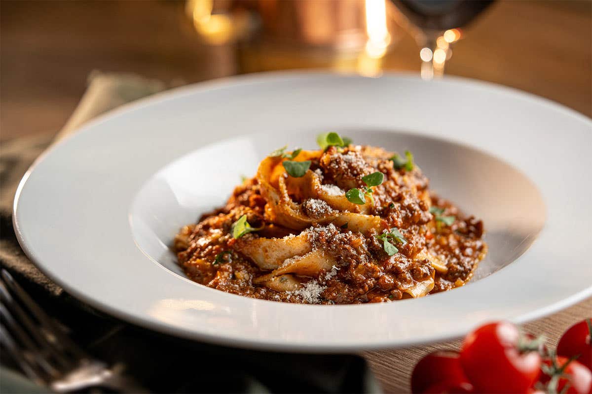 Flat noodle pasta with a Bolognese and topped with parsley and grated cheese. 
