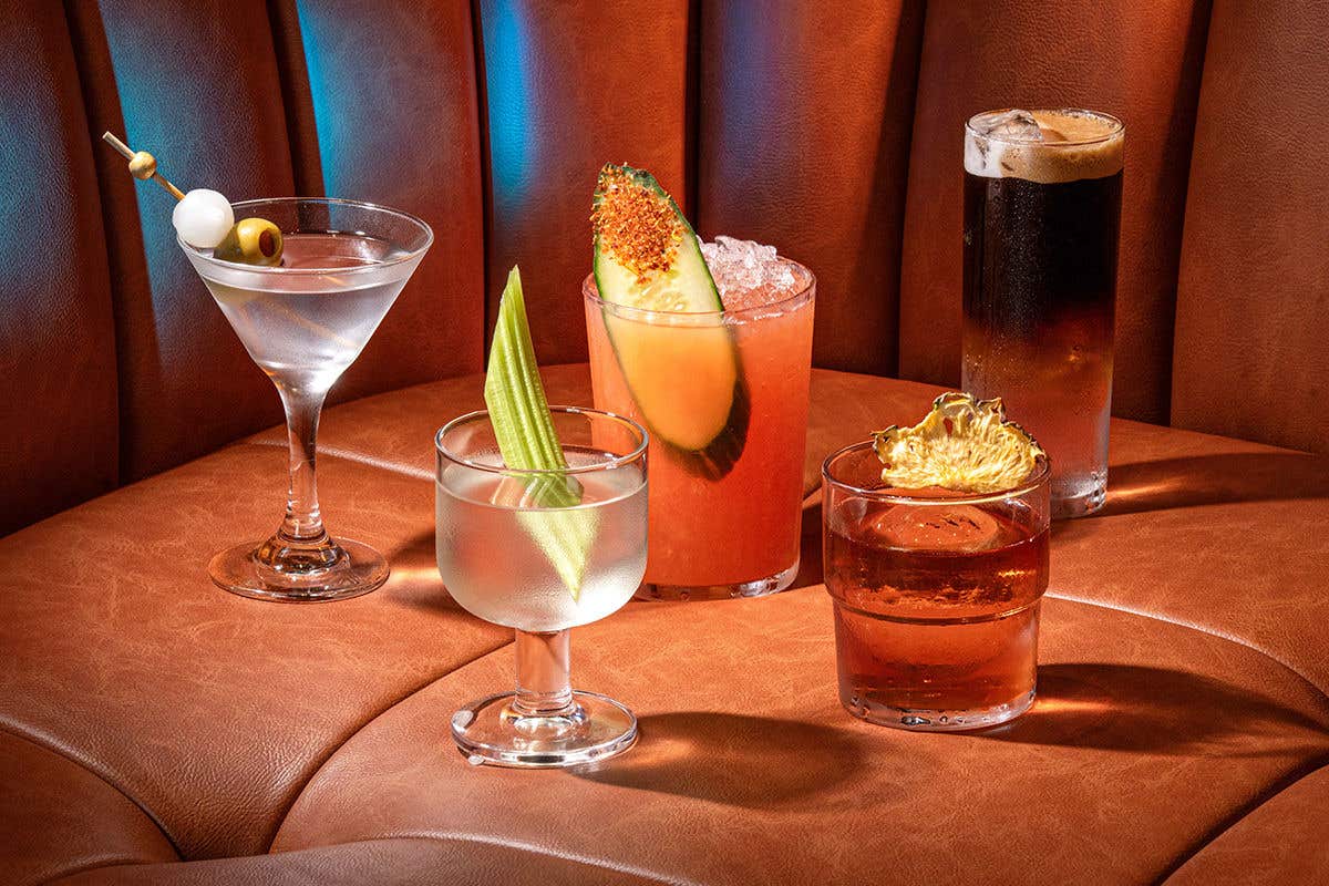 5 different cocktails on a brown sofa. 